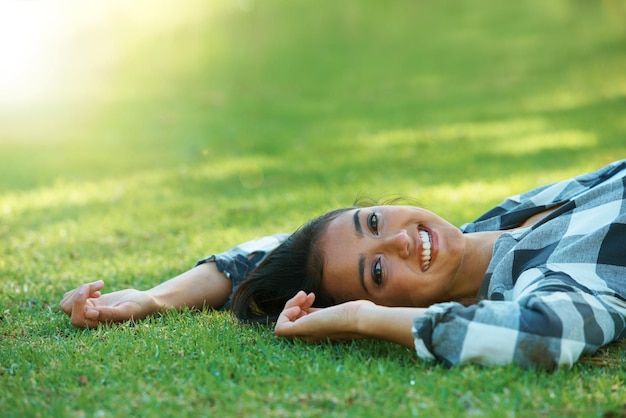 Space portrait or happy woman on lawn to relax for rest in park nature or field for peace in USA Flare travel or female person on break with smile on outdoor summer vacation or holiday on grass