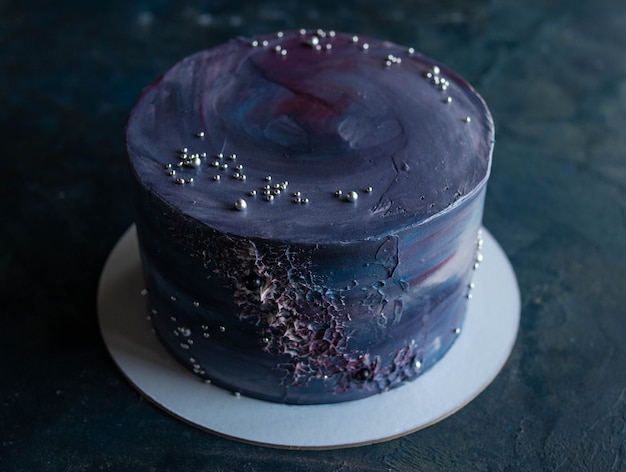 Space-themed cake. Cake decorated with stars on a dark background. NASA cake. Copy space, close up.