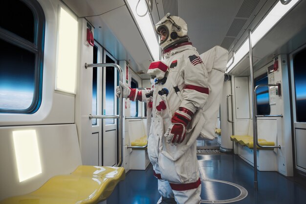 未来の駅にいる宇宙飛行士。宇宙服を着た男が仕事に出て電車に乗る