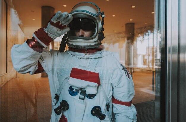 Spaceman in a futuristic station. Man with space suit walking in an urban area