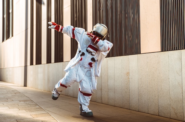 Spaceman in a futuristic station. Man with space suit walking in an urban area
