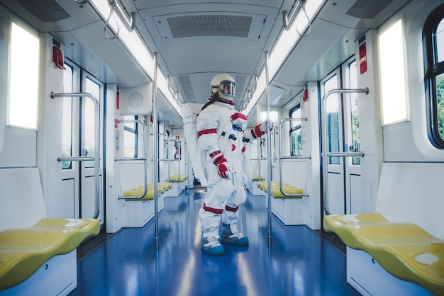 Космонавт на футуристической станции. человек в скафандре уходит на работу и садится на поезд