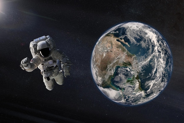 Spaceman in outer space with Earth planet Elements of this image furnished by NASA