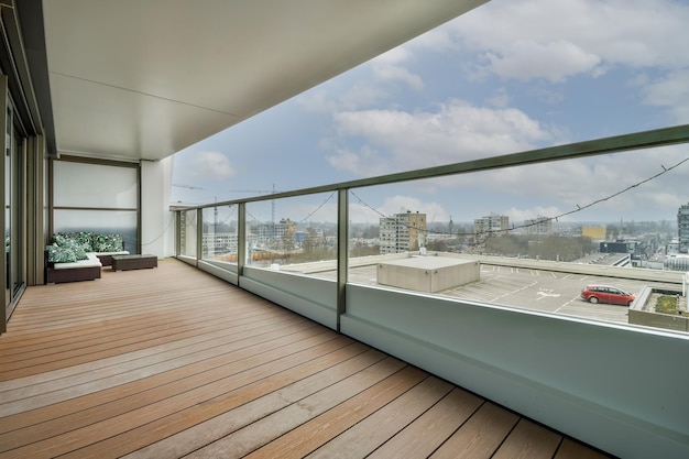 Spacious balcony with wooden floors and a glass fence in a modern style