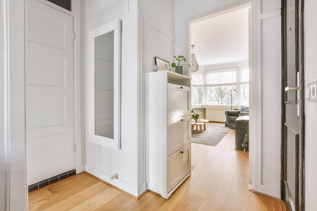 A spacious bright corridor with a mirror and access to the living room of a cozy house