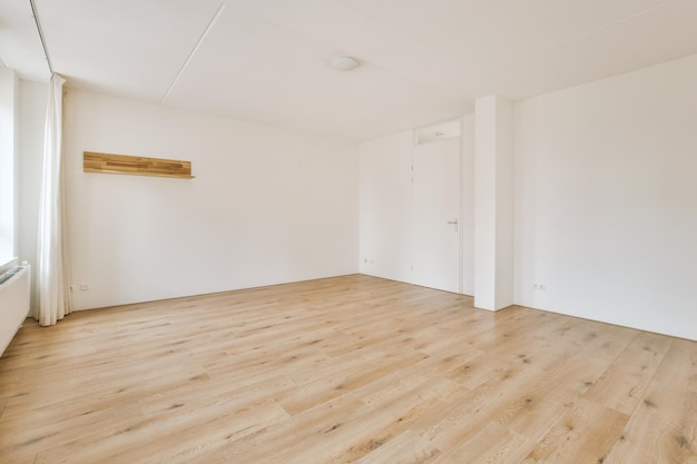 Spacious bright empty room in white tones with laminate flooring in a cozy house