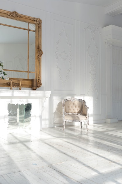 アンティークな装飾と古いスタイルの美しいシックな家具を備えたスタイリッシュでクラシックなデザインの広々とした明るいリビングルーム