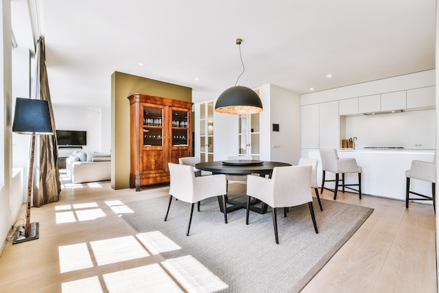 Spacious dining room with table and chairs in modern apartment in minimal style