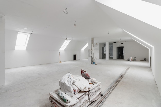 Spacious empty rooms in the attic floor after filling out the work on the wall and ceiling