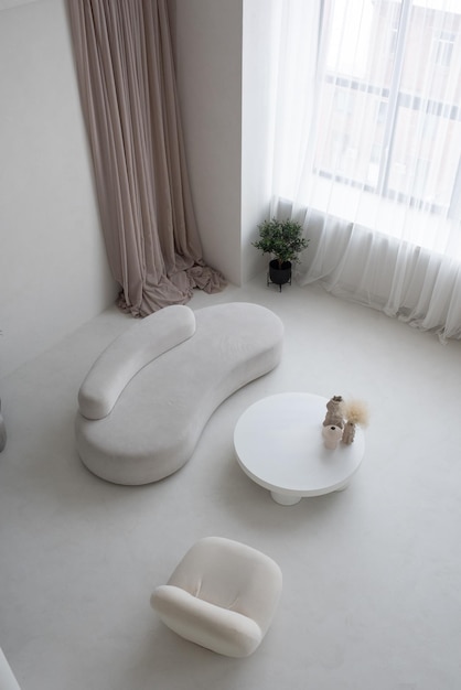 흰색 소파와 안락의자와 꽃병이 있는 원형 테이블이 있는 넓은 거실
