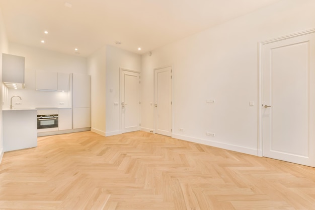 A spacious room with parquet floors and a corner kitchen in a minimalist style in a modern house