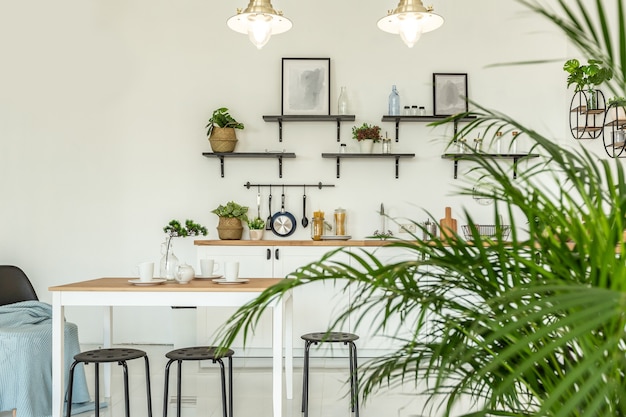 Foto ampio monolocale decorato con legno e bianco. design minimalista con enormi finestre alla luce del sole. zona cucina e zona giorno