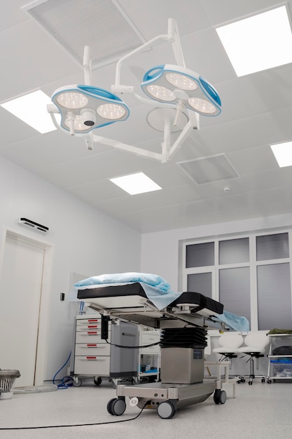 Spacious wellequipped operating room in the center of which there is an operating table and an operating lamp is directed to it The concept of health care saving life