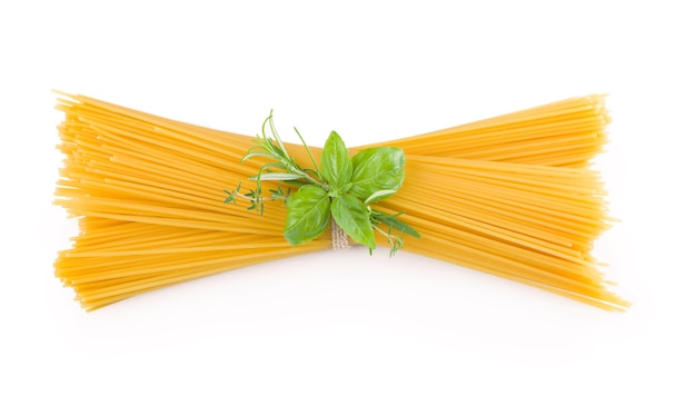 Foto spaghetti e basilico isolati su priorità bassa bianca.