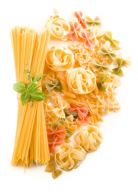 Spaghetti e basilico isolati su priorità bassa bianca.