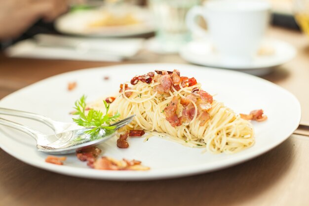 spaghetti becon on white disc in resturant