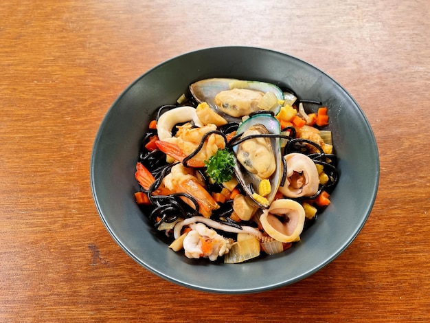 Foto gli spaghetti neri di calamaro ai frutti di mare come gamberi calamari cozze verdure