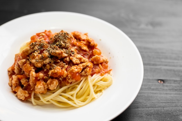 Spaghetti on black wooden background  