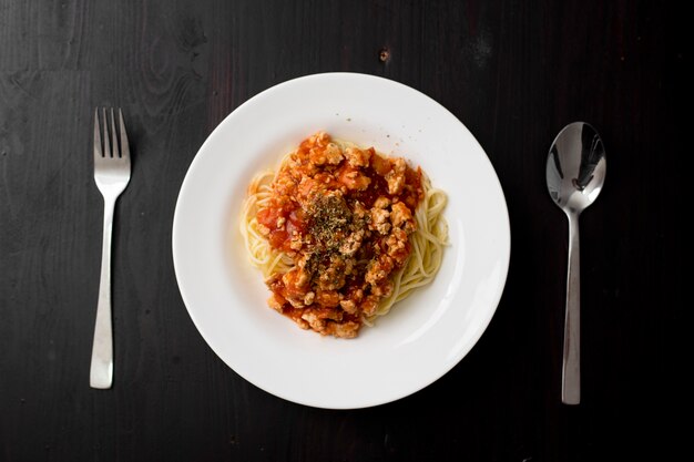 Spaghetti on black wooden background  