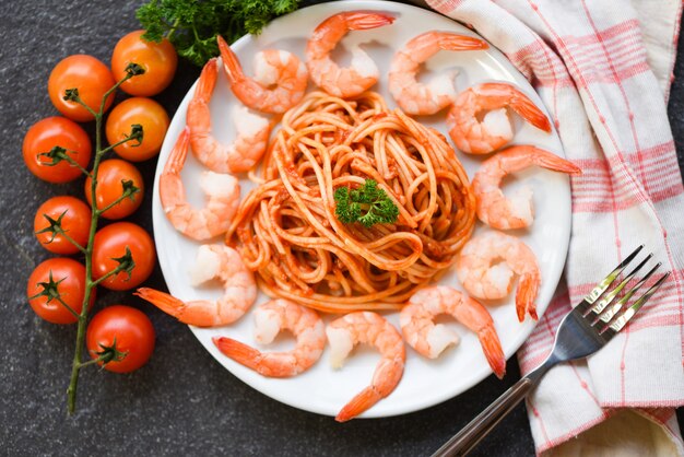 Spaghetti bolognese italian pasta with shrimp prawn served on white plate with tomato