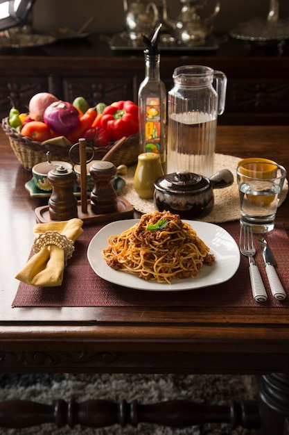 Spaghetti ragù alla bolognese carne macinata perù peruviana comfort food mise en place tavola di legno