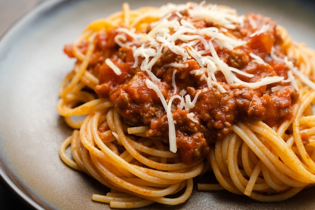 Spaghetti alla bolognese o salsa di pomodoro su una tavola di legno scuro