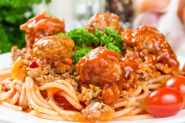 Spaghetti bolognese with beef meatballs and parsley