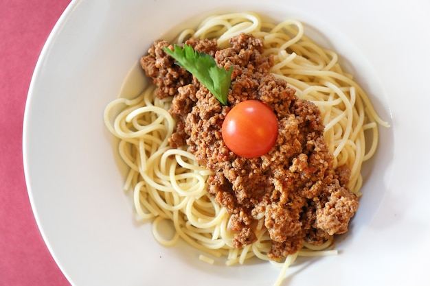 Spaghetti Bolognese with Parmesan Cheese and Basil in a Plate