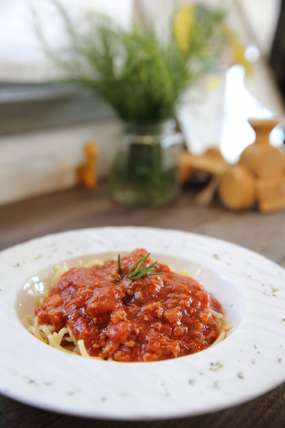 Foto spaghetti alla bolognese su fondo di legno