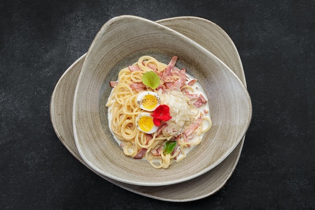 Spaghetti alla carbonara su un piatto su fondo scuro