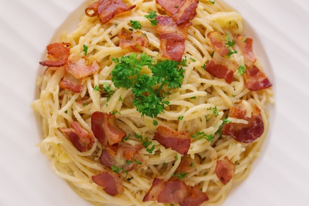 Spaghetti carbonara with bacon and cheese sprinkle with chopped parsley 