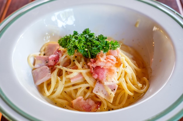 Spaghetti Carbonara with bacon ham and vegetable in bowl