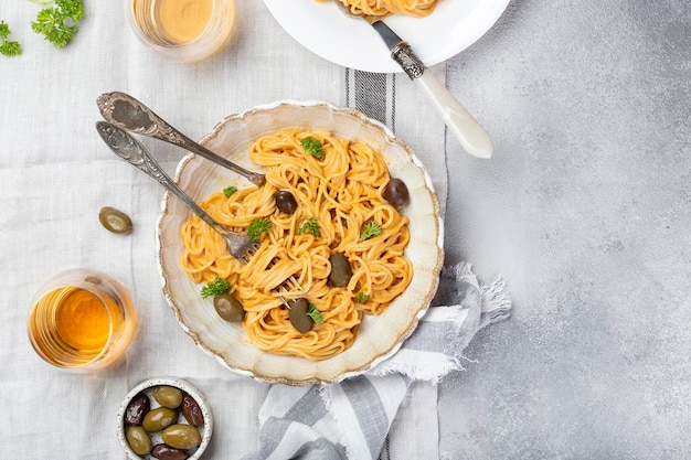 Spaghetti in creamy tomato sauce with olives and Parmesan