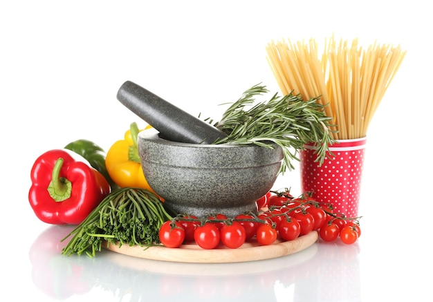 Spaghetti in cup rosemary in mortar and vegetables on wooden board isolated on white