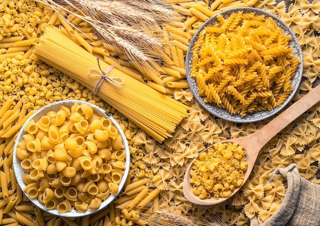 Spaghetti e diversi tipi di pasta in un piatto e in tavola.