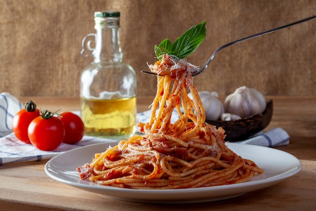 Foto spaghetti in un piatto su un fondo di legno