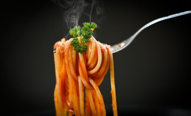 spaghetti on fork and black background