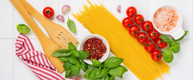 스파게티, 신선한 토마토, 허브 및 향신료. 흰색 배경, 평면도에 고립 된 건강 식품 재료의 구성. 모의.