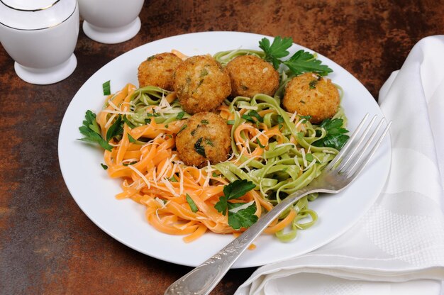 Spaghetti from carrots and spinach with chicken meatballs flavored cheese parmesan, herb