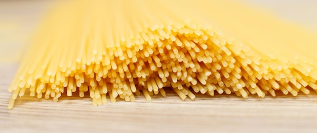 Spaghetti gele achtergrond close rauwe pasta macro