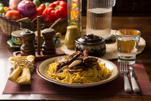 Spaghetti huancaina saus en lomo saltado Peru Peruaans comfort food mise en place houten tafel