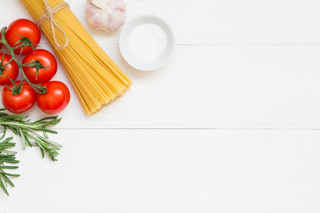 スパゲッティ成分、トマト、ローズマリー、塩、ニンニクの概念白い背景の上