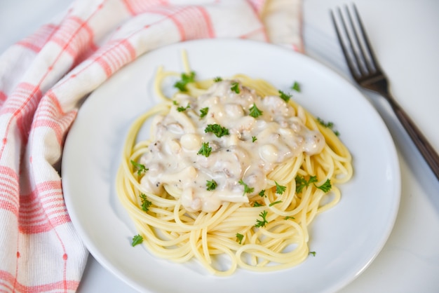 Foto la pasta italiana degli spaghetti è servito sul piatto bianco con prezzemolo nel concetto italiano dell'alimento e del menu del ristorante - carbonara degli spaghetti