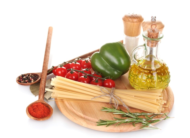 Spaghetti jar of oil spices and vegetables on wooden board isolated on white