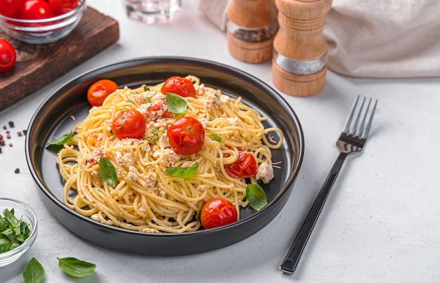 Spaghetti met feta-kaas, cherrytomaatjes en kruiden Zijaanzicht kopieerruimte