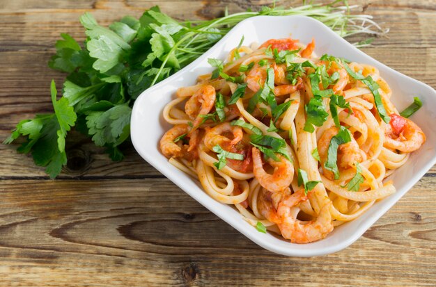 Spaghetti met garnalen in tomatensaus met kruiden.