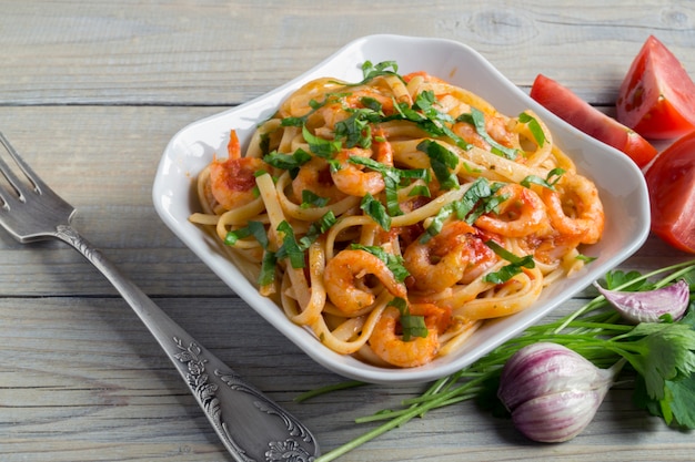 Spaghetti met garnalen in tomatensaus met kruiden.