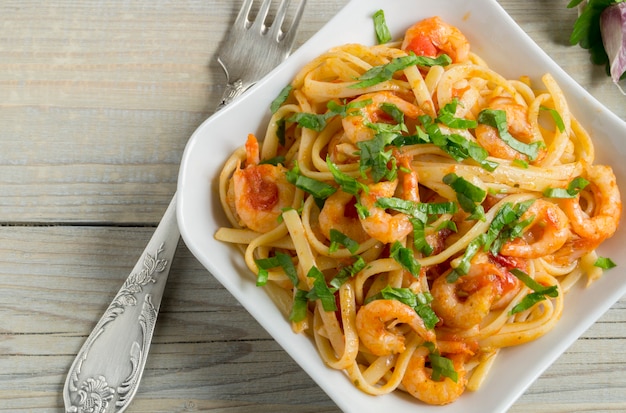 Spaghetti met garnalen in tomatensaus met kruiden.