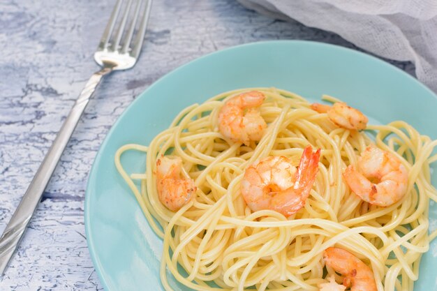 Spaghetti met garnalen op blauwe platen. Een heerlijk diner.