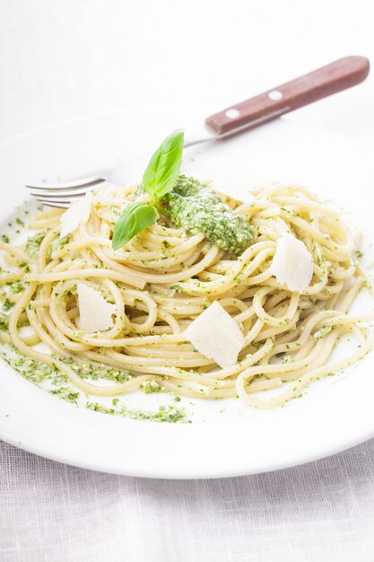 Spaghetti met groene pesto en parmezaan op het bord